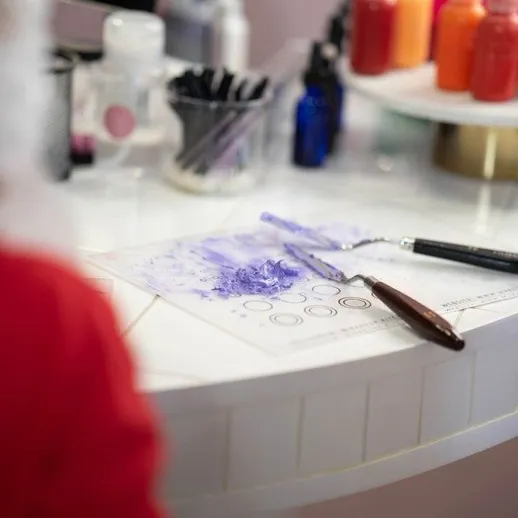 Процесс создания ногтевого дизайна в студии маникюра с инструментами и красками