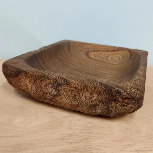 Тайская деревянная чаша ручной работы, изготовленная из темного дерева с уникальной текстурой и формой, на столе