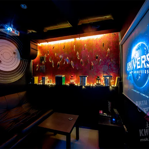 Комната для отдыха с экраном кинотеатра и тематическим декором, оформленная к празднованию юбилея