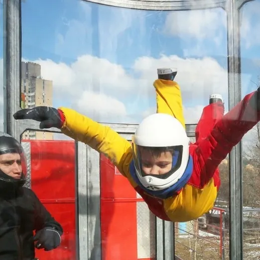 Человек в свободном падении в аэродинамической трубе в честь приятного солнечного дня