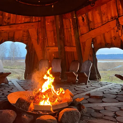 Костер горит в уютном деревянном беседке у озера в спокойный вечер