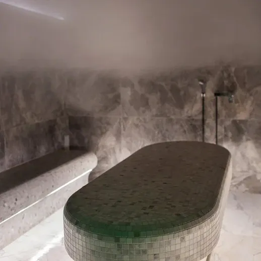 Внутри парной с мозаичным столом и кафельными стенами в светлом тумане