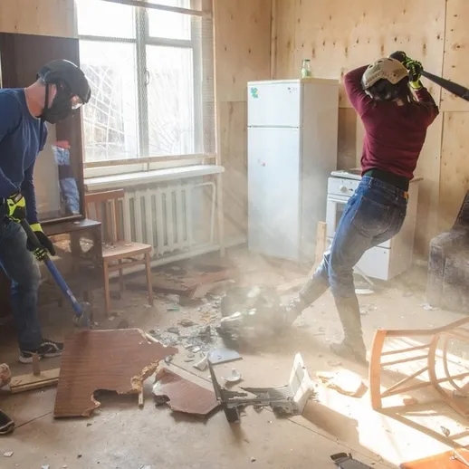 Разрушение предметов в заброшенной комнате: молодые люди разбивают мебель в проекте по разрушению