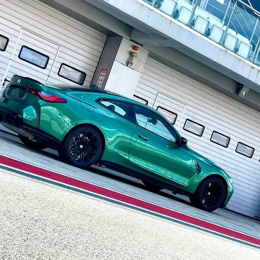 Ярко-зеленый спортивный автомобиль на автодроме во время тестирования