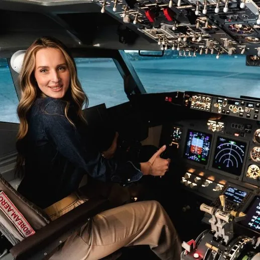 Женщина находится в кабине пилота и управляет самолетом на аэродроме