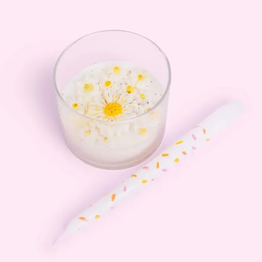 Ароматная свеча с цветами в стеклянной банке на нежном розовом фоне