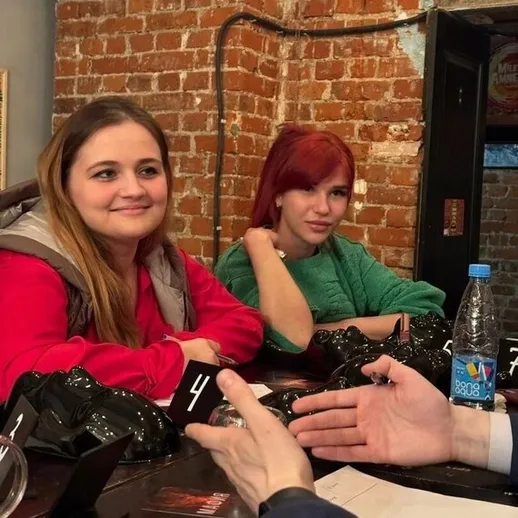 Встреча друзей в уютном заведении с кирпичными стенами в вечернее время