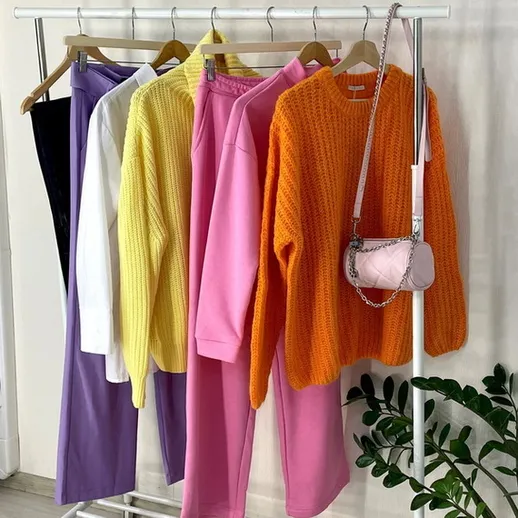 Яркие осенние наряды на вешалке в магазине одежды, заполненные светлыми и теплые оттенками