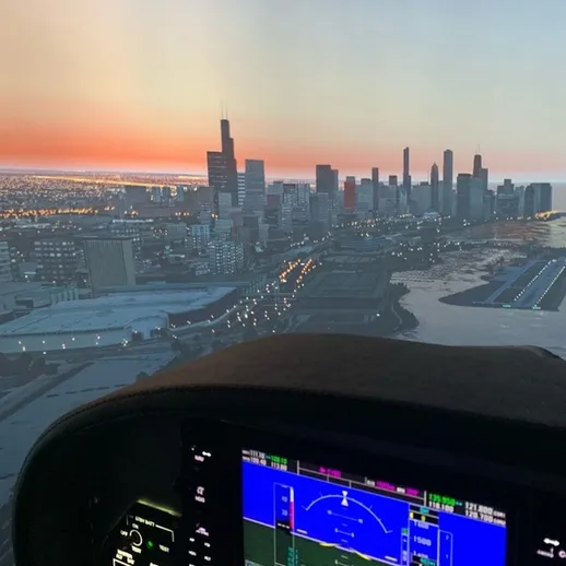 Восход солнца над городом: вид из кабины вертолета на небоскребы и побережье