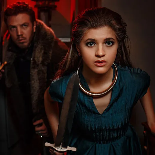 Молодая женщина с мечом и мужчина в тёмном коридоре готовятся к неожиданному событию в старинном здании