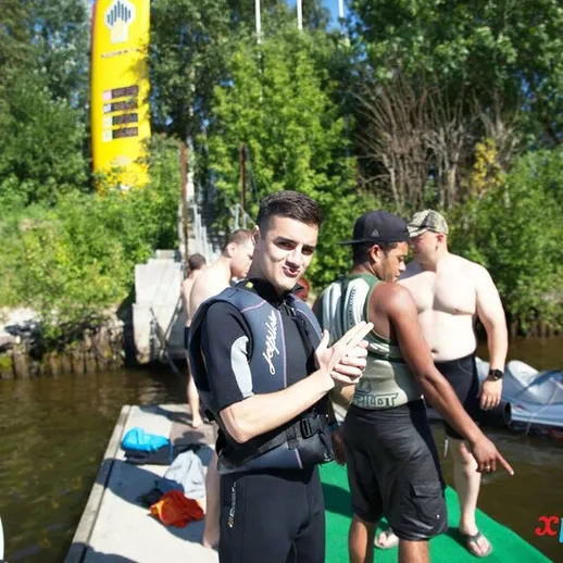 Молодой человек на причале у реки, готовящийся к водным приключениям в летний день с друзьями