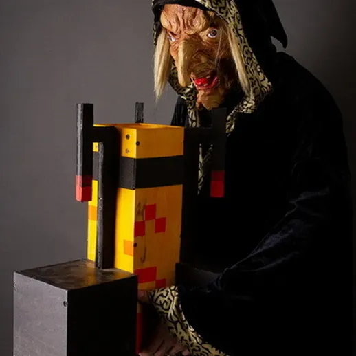 Страшное существо в черной мантии держит цветной объект, создавая атмосферу мистики и таинственности