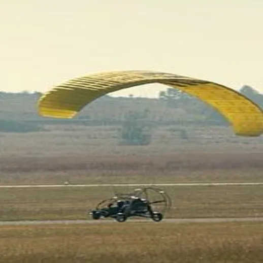 Полет парамотора на фоне поля в солнечный день