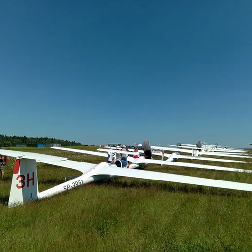 Летательные аппараты на взлетной полосе в солнечный день, ожидают старта на небольшом аэродроме