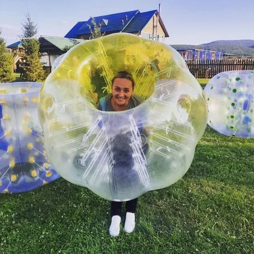 Игривая женщина в большом надувном пузыре на отдыхе на природе