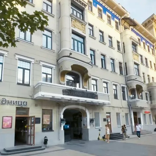 Историческое здание на центральной улице города, где люди проходят мимо и наслаждаются деятельностью в ясный день