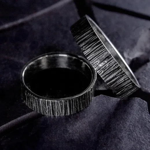 Изящные обручальные кольца на черной поверхности, созданные для символа вечной любви и связи между партнерами