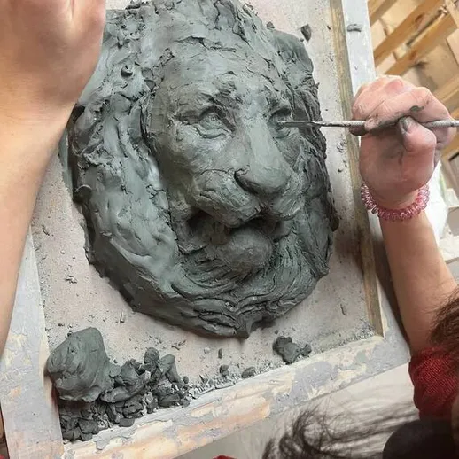 Создание скульптуры льва из глины в художественной студии во время урока