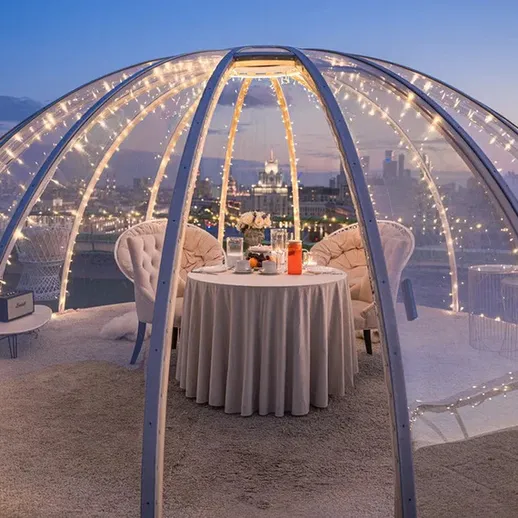 Уютный ресторан на крыше с прозрачным куполом в вечернее время в Москве
