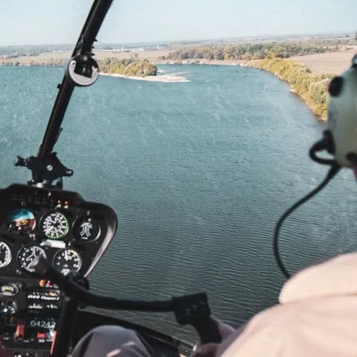 Полет на вертолете над живописной рекой в ясный день