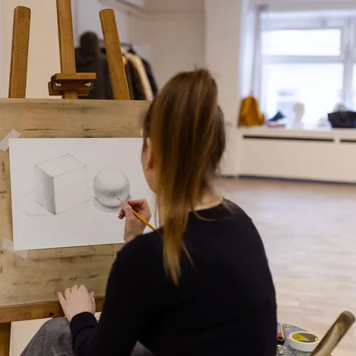 Художник создает натюрморт в светлом художественном пространстве