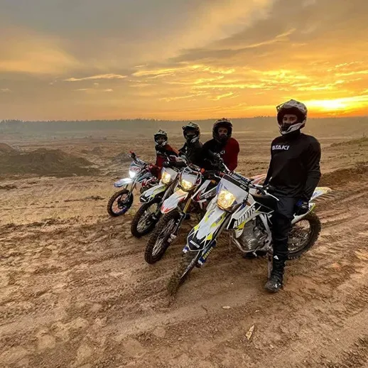 Вечерние покатушки на моторах по песчаным дюнам при закате, группа на внедорожниках