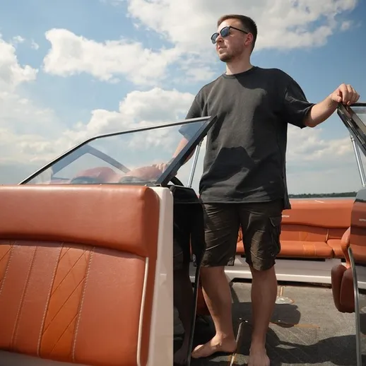 Молодой человек на лодке наслаждается солнечным днем на водоеме в летнее время