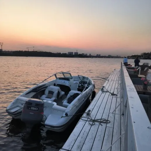 Закат над рекой, катер у причала, вечерний отдых на воде