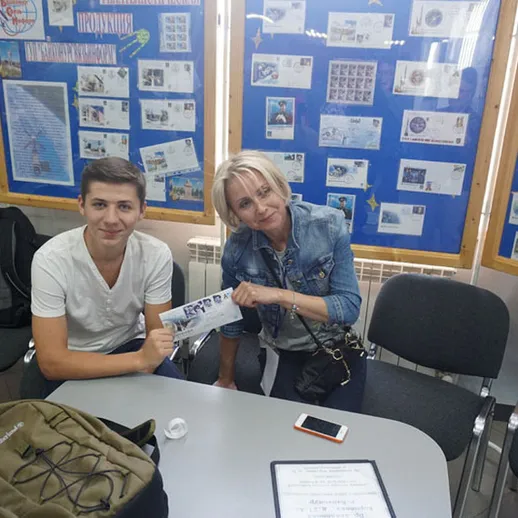 Встреча двух людей в комнате с выставкой на стенах в будний день