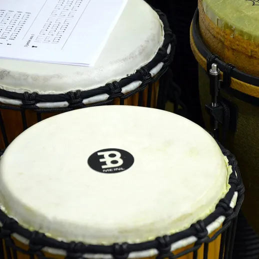 Музыкальные инструменты на репетиции, включая бонгос и нотный лист, в уютной комнате в вечернее время