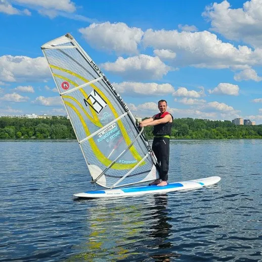 Мужчина занимается виндсерфингом на реке в Москве в ясный день