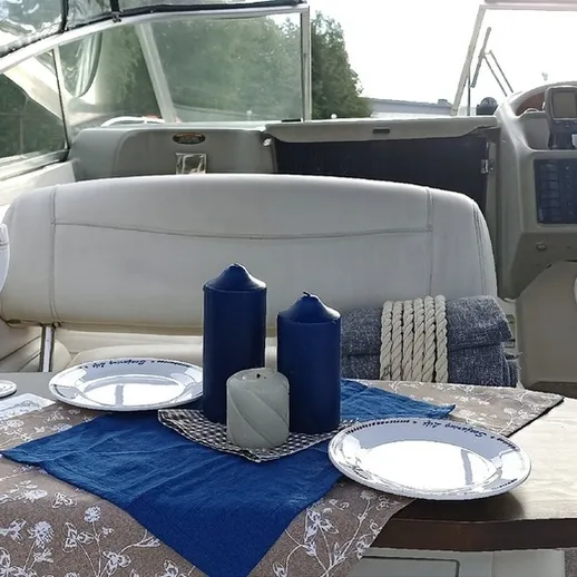 Элегантно накрытый стол на лодке для романтического ужина на воде в ясный день