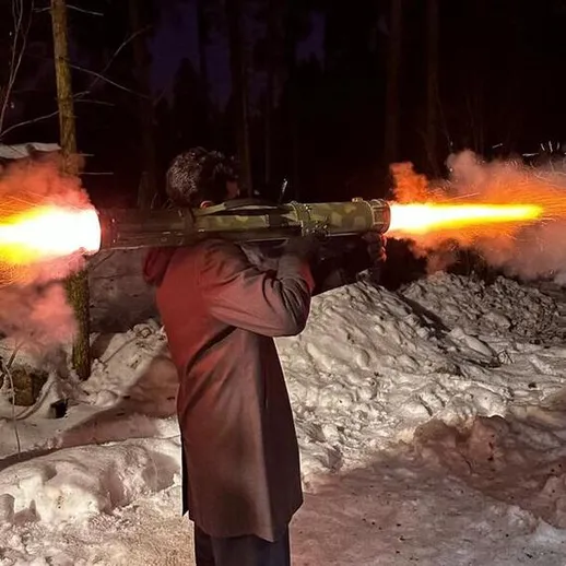Человек стреляет из ракетной установки в зимнем лесу ночью