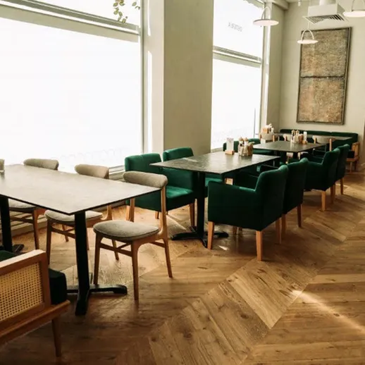 Современное кафе с уютной атмосферой и зелеными стульями в обеденное время