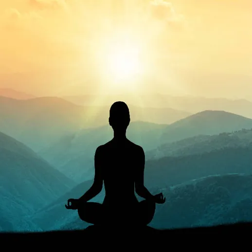 Медитация на фоне горного заката с silhouett’ой человека, сидящего в позе лотоса