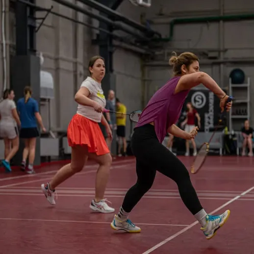 Женщины играют в теннис в спортивном зале, тренируясь на корте в течение весеннего дня
