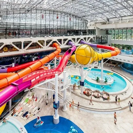 Внутренний аквапарк с водными горками и зоной отдыха в современном здании