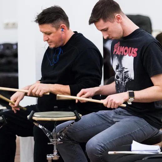 Музыканты репетируют ритмы на барабанах в учебном зале в Москве, осень 2023 года