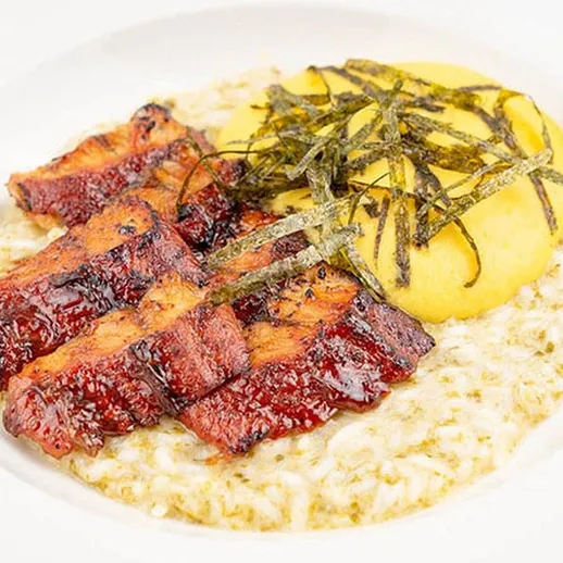 Вкусное блюдо с курицей, картофельным пюре и зелеными водорослями, поданное на белой тарелке