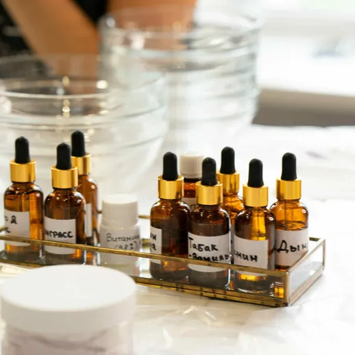 Набор эфирных масел и косметических флаконов на столе во время процедуры по уходу за кожей