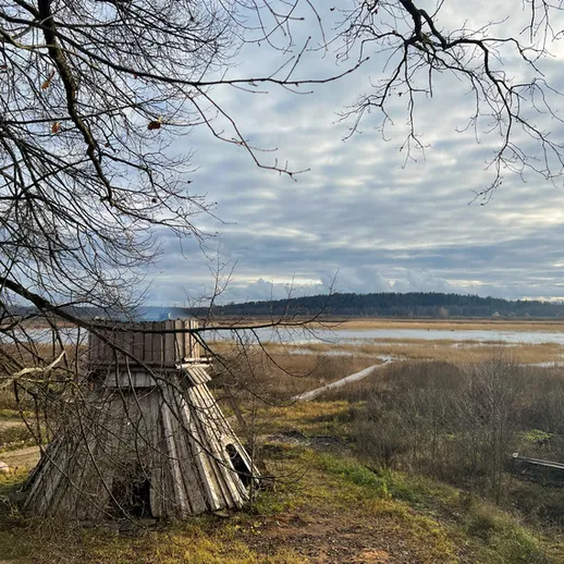 Пейзаж с деревянной конструкцией и рекой в осенний день у берегов