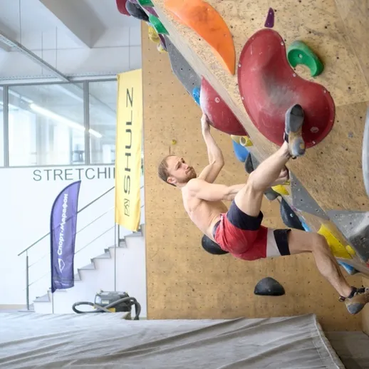 Мужчина занимается скалолазанием в спортивном центре в Токио на стенде для трудностей