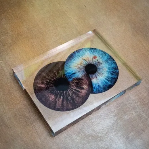 Описание двух глаз в кристалле на деревянном столе в помещении