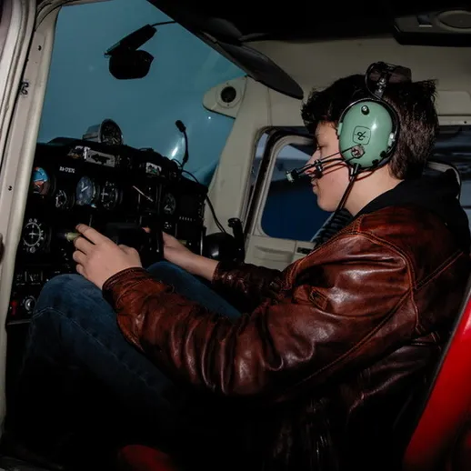 Молодой пилот управляет самолетом в облачном небе во время учебного полета