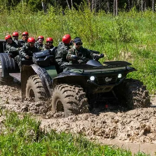 Люди на вездеходе преодолевают болотистую местность в лесу, наслаждаясь активным отдыхом весной