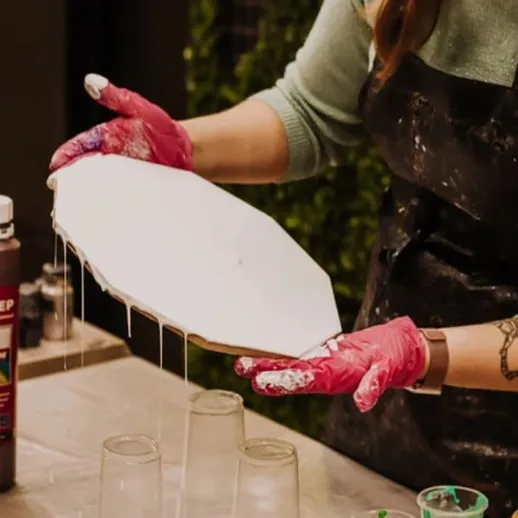 Создание художественного панно в мастерской, художница делает акриловую заливку на белом холсте