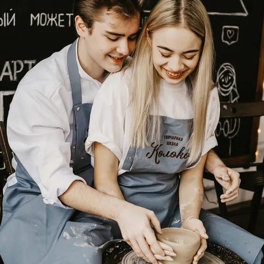 Молодая пара лепит из глины в мастерской керамики в уютной атмосфере вечером