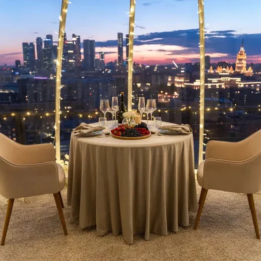 Романтический ужин на крыше с видом на вечерний город в огнях