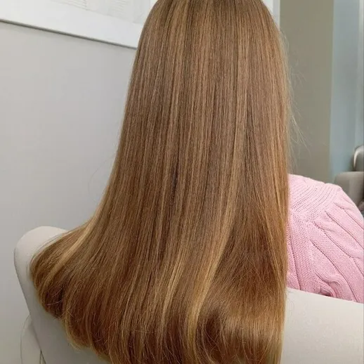 Прическа с длинными гладкими волосами светло-коричневого цвета в современном интерьере