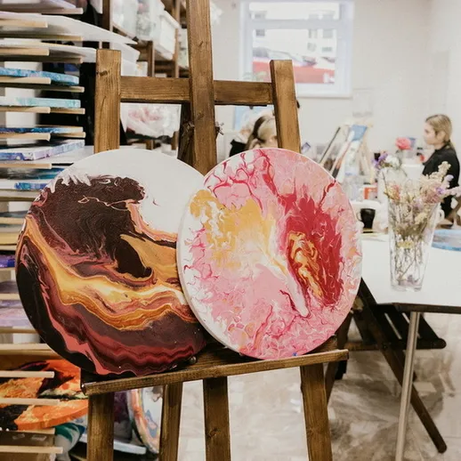 Картины на мольберте в художественной студии, созданные в красочных абстрактных стилях, в дневное время